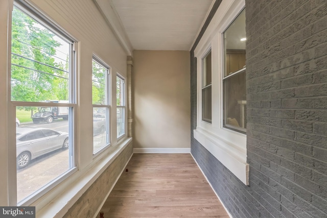 unfurnished sunroom with wood finished floors and baseboards