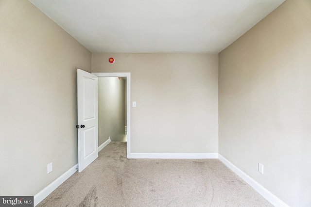 spare room featuring carpet and baseboards