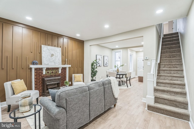 living area with stairway, light wood-style flooring, recessed lighting, a fireplace, and baseboards
