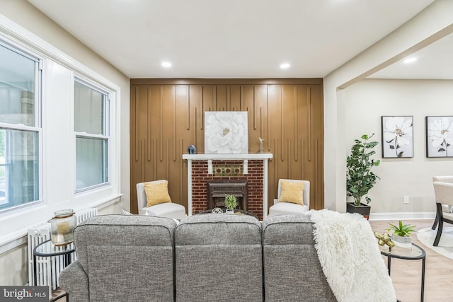 living room with wood finished floors, a fireplace, recessed lighting, and baseboards