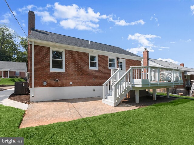 3817 Arbutus Ave, Baltimore, MD 21207 - back of house featuring brick siding, a yard, cooling unit, a wooden deck, and a chimney