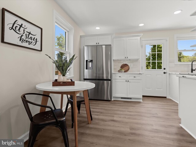 3817 Arbutus Ave, Baltimore, MD 21207 - kitchen with stainless steel fridge with ice dispenser, tasteful backsplash, healthy amount of natural light, white cabinets, and recessed lighting