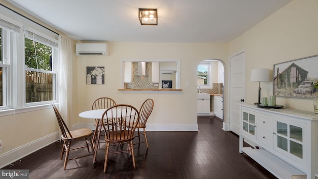 409 W 10th Ave, Conshohocken, PA 19428 - dining room with an AC wall unit, dark wood-style floors, arched walkways, and baseboards