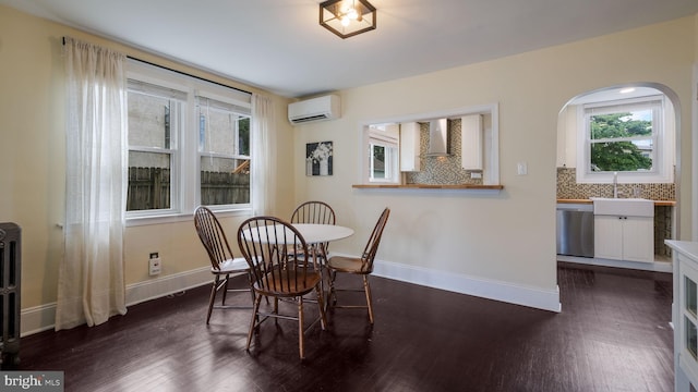 409 W 10th Ave, Conshohocken, PA 19428 - dining room featuring a wall mounted AC, dark wood-style flooring, baseboards, and arched walkways