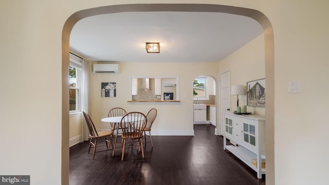 409 W 10th Ave, Conshohocken, PA 19428 - dining space featuring a wall unit AC, arched walkways, and wood finished floors