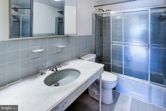 4201 Cathedral Ave NW Unit 1004E, Washington, DC 20016 - full bathroom with toilet, a sink, tile patterned floors, tile walls, and shower / bath combination with glass door