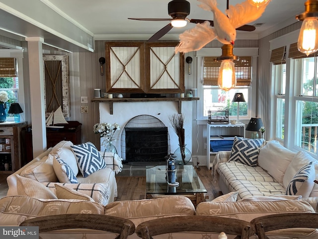 204 Coral St, Beach Haven, NJ 08008 - living area featuring ceiling fan, a fireplace with raised hearth, wood finished floors, healthy amount of natural light, and ornamental molding