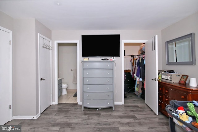 220 Brian Dr, Enola, PA 17025 - bedroom featuring a walk in closet, wood finished floors, a closet, connected bathroom, and baseboards