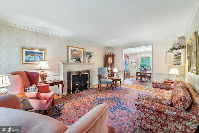15320 Durant St, Silver Spring, MD 20905 - living room featuring a chandelier, wood finished floors, crown molding, wallpapered walls, and a fireplace