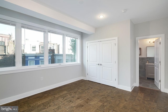1212 E Susquehanna Ave Unit D, Philadelphia, PA 19125 - unfurnished bedroom with baseboards, a closet, dark wood-style flooring, and connected bathroom