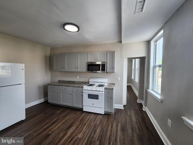 1000 E Preston St, Baltimore, MD 21202 - kitchen featuring white appliances, gray cabinets, dark wood finished floors, baseboards, and light stone counters