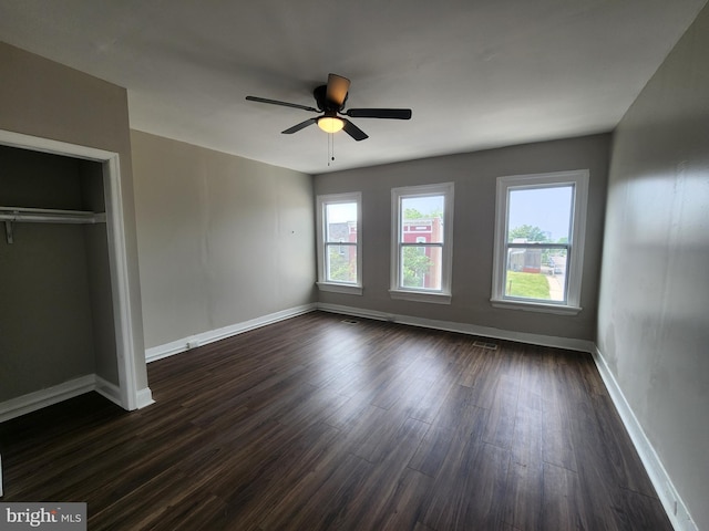 1000 E Preston St, Baltimore, MD 21202 - unfurnished bedroom with baseboards, dark wood-type flooring, and a ceiling fan