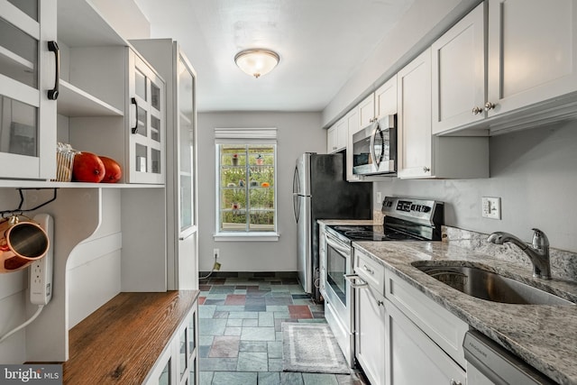 922 Montgomery Ave Unit J-1, Bryn Mawr, PA 19010 - kitchen with appliances with stainless steel finishes, a sink, dark stone finish flooring, light stone countertops, and white cabinetry