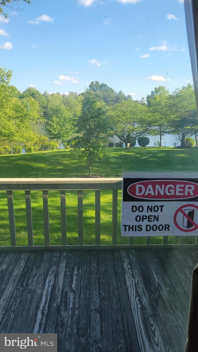 wooden deck featuring a yard and a water view