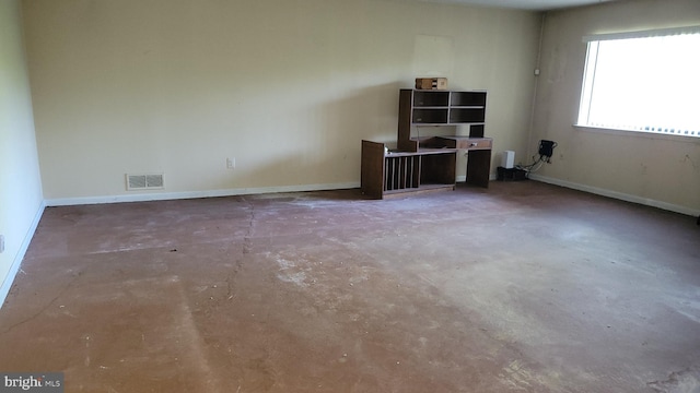 unfurnished room featuring unfinished concrete flooring and baseboards