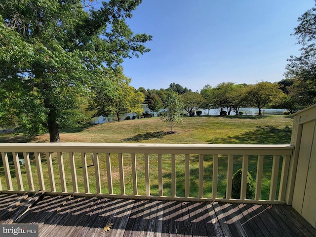 wooden terrace with a lawn and a water view