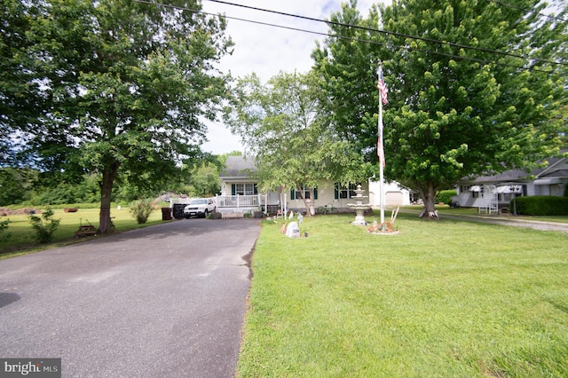 5294 Bucktown Rd, Cambridge, MD 21613 - obstructed view of property with a porch, asphalt driveway, and a front lawn