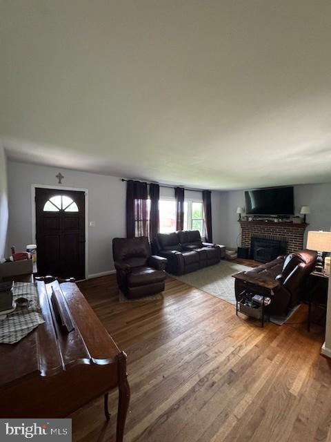 15510 Baden Naylor Rd, Brandywine, MD 20613 - living area featuring a brick fireplace, wood finished floors, and baseboards