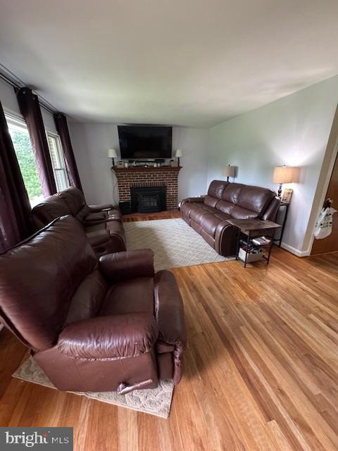 15510 Baden Naylor Rd, Brandywine, MD 20613 - living room featuring a brick fireplace and wood finished floors