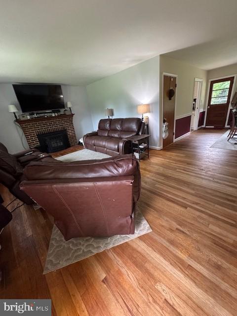 15510 Baden Naylor Rd, Brandywine, MD 20613 - living area with a brick fireplace, wood finished floors, and baseboards