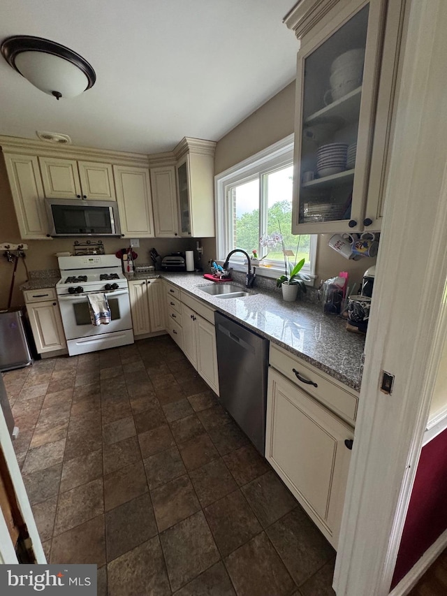 15510 Baden Naylor Rd, Brandywine, MD 20613 - kitchen featuring cream cabinetry, appliances with stainless steel finishes, a sink, and glass insert cabinets