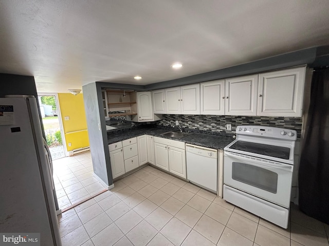 303 Main St, Ellendale, DE 19941 - kitchen with white appliances, a sink, light tile patterned floors, dark countertops, and recessed lighting