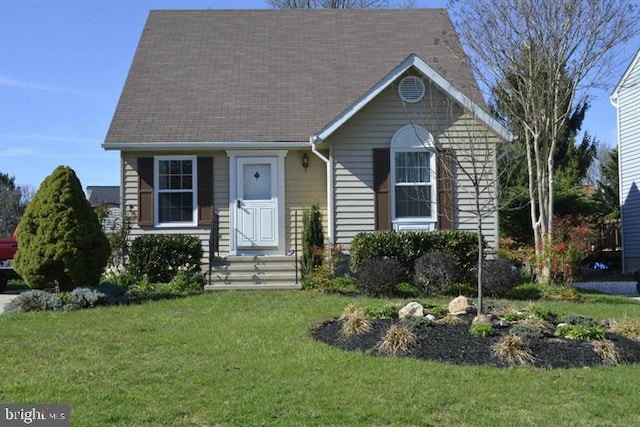 view of front of house with a front yard and roof with shingles