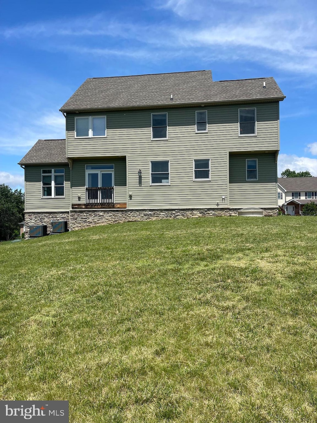 rear view of property featuring central AC unit and a yard