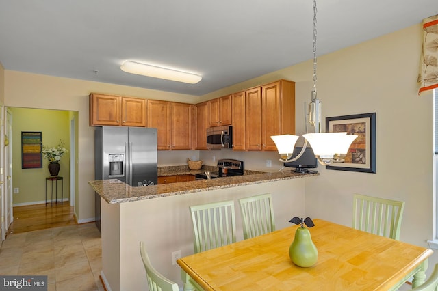 7305 Brookview Rd Unit 207, Elkridge, MD 21075 - kitchen with appliances with stainless steel finishes, a peninsula, stone countertops, brown cabinets, and baseboards