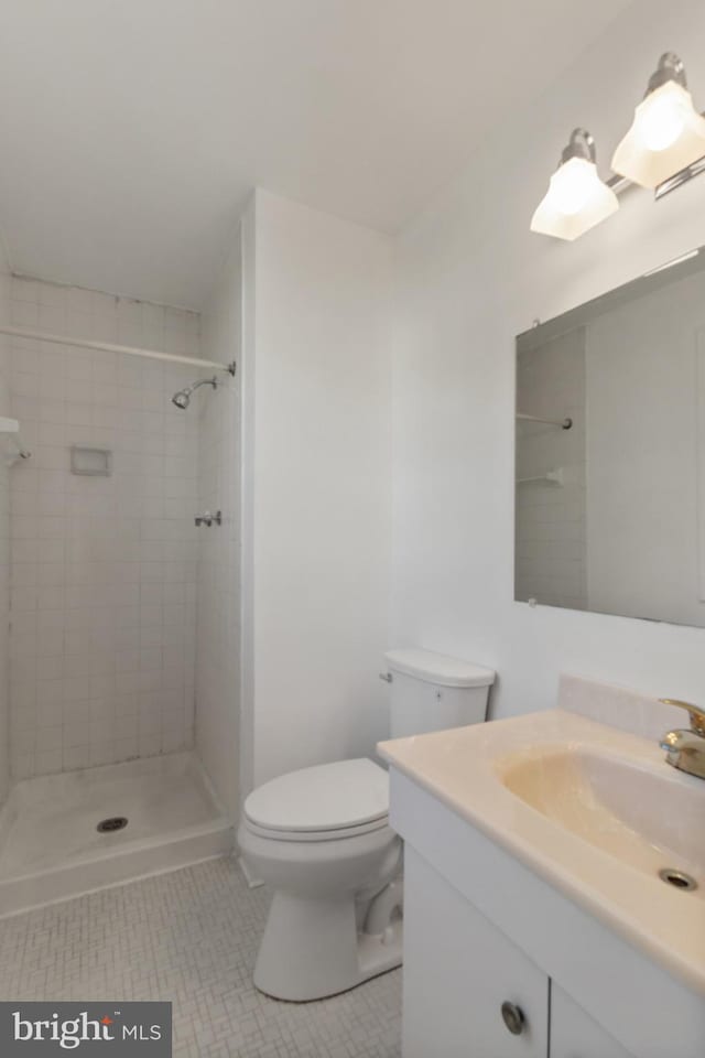 7602 Woodruff Ct, Laurel, MD 20707 - bathroom with tile patterned flooring, toilet, tiled shower, and vanity