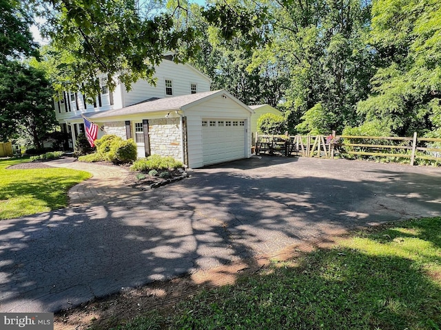 1027 Hart Rd, Baltimore, MD 21286 - view of side of home with asphalt driveway, a garage, and stone siding