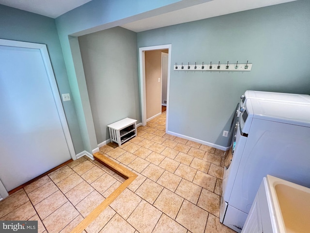 1027 Hart Rd, Baltimore, MD 21286 - laundry area featuring washing machine and clothes dryer, baseboards, and light tile patterned floors