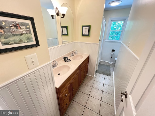 1027 Hart Rd, Baltimore, MD 21286 - full bathroom featuring a wainscoted wall, double vanity, tile patterned flooring, and toilet