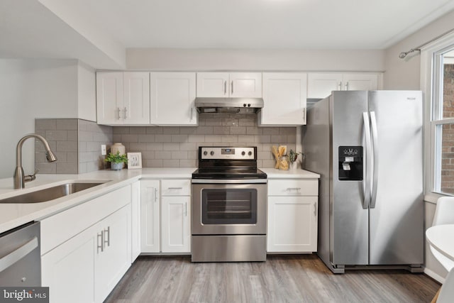 6842 Heatherway Ct, Alexandria, VA 22315 - kitchen featuring appliances with stainless steel finishes, a sink, under cabinet range hood, light wood-type flooring, and light countertops