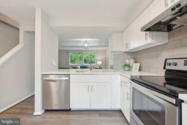 6842 Heatherway Ct, Alexandria, VA 22315 - kitchen with stainless steel appliances, under cabinet range hood, a sink, backsplash, and white cabinetry