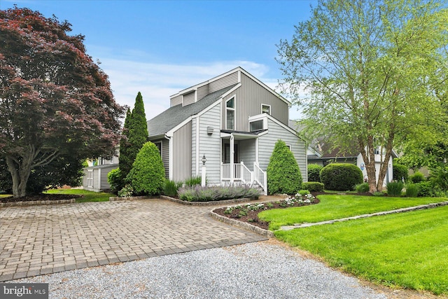 537 Candlelight Ln, Bethany Beach, DE 19930 - mid-century home with a front lawn, a shingled roof, and driveway