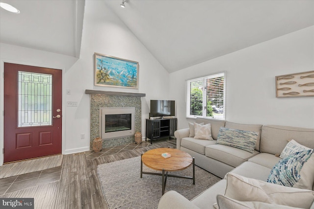 537 Candlelight Ln, Bethany Beach, DE 19930 - living area featuring high vaulted ceiling, a tile fireplace, wood finished floors, and baseboards