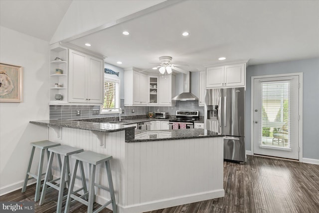 537 Candlelight Ln, Bethany Beach, DE 19930 - kitchen featuring appliances with stainless steel finishes, wall chimney exhaust hood, a sink, white cabinetry, and dark stone countertops