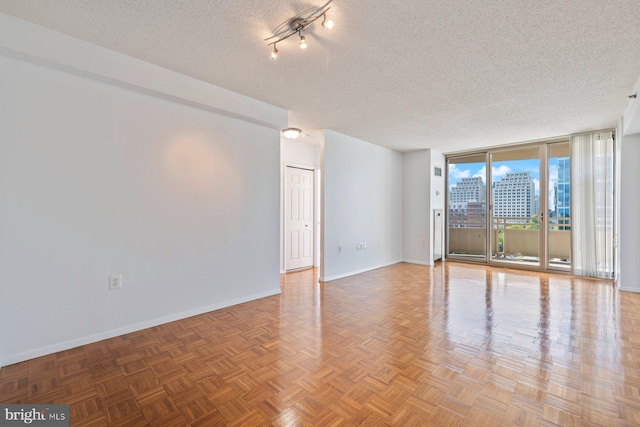 4801 Fairmont Ave Unit 804, Bethesda, MD 20814 - spare room featuring baseboards, a textured ceiling, a wall of windows, and a city view