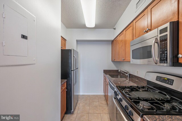 4801 Fairmont Ave Unit 804, Bethesda, MD 20814 - kitchen with appliances with stainless steel finishes, a sink, electric panel, dark stone counters, and brown cabinetry