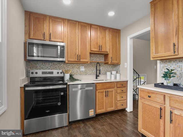 13214 Holdridge Rd, Silver Spring, MD 20906 - kitchen featuring stainless steel appliances, a sink, light countertops, backsplash, and dark wood-style floors
