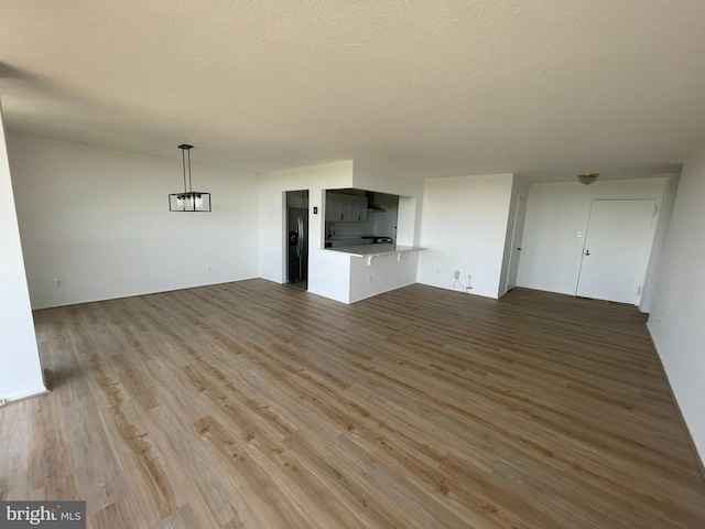 unfurnished living room with wood finished floors and a textured ceiling