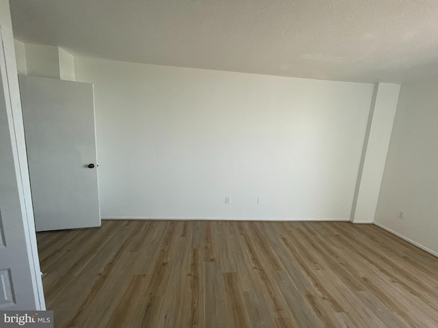 additional living space featuring wood finished floors and baseboards