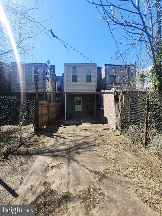 713 N Payson St, Baltimore, MD 21217 - rear view of property featuring fence and driveway