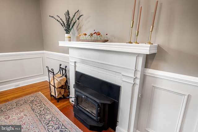 1602 S Rolling Rd, Halethorpe, MD 21227 - detailed view of a wainscoted wall, wood finished floors, and a wood stove