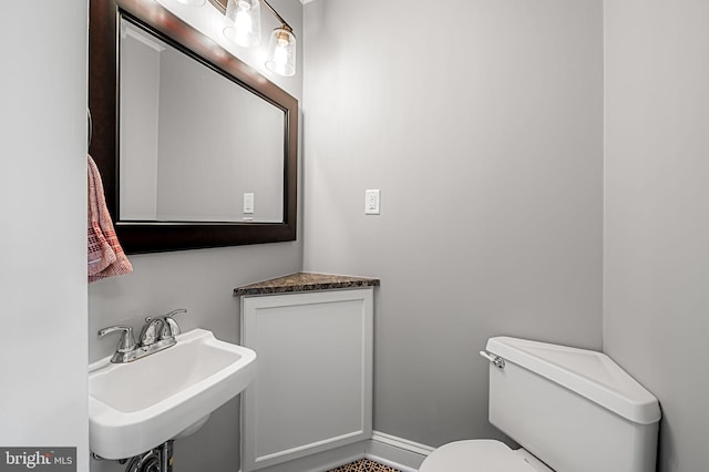 1602 S Rolling Rd, Halethorpe, MD 21227 - bathroom featuring a sink, toilet, and baseboards