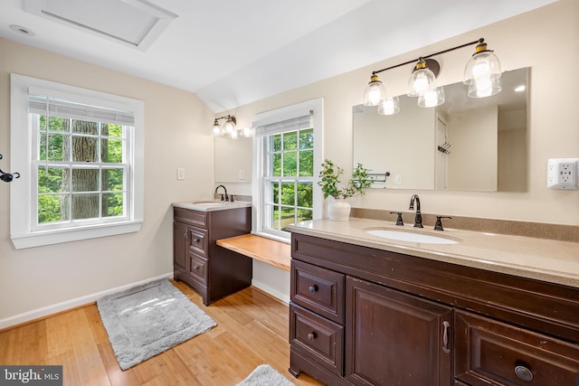 1602 S Rolling Rd, Halethorpe, MD 21227 - bathroom featuring two vanities, wood finished floors, baseboards, and vaulted ceiling