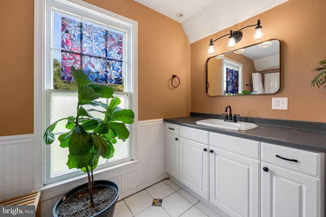 1602 S Rolling Rd, Halethorpe, MD 21227 - bathroom featuring vanity, a wainscoted wall, vaulted ceiling, and tile patterned floors