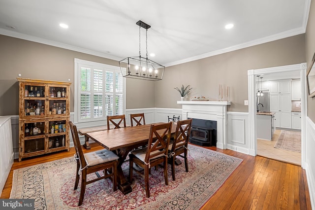1602 S Rolling Rd, Halethorpe, MD 21227 - dining area with light wood-style flooring, crown molding, a wainscoted wall, a chandelier, and recessed lighting