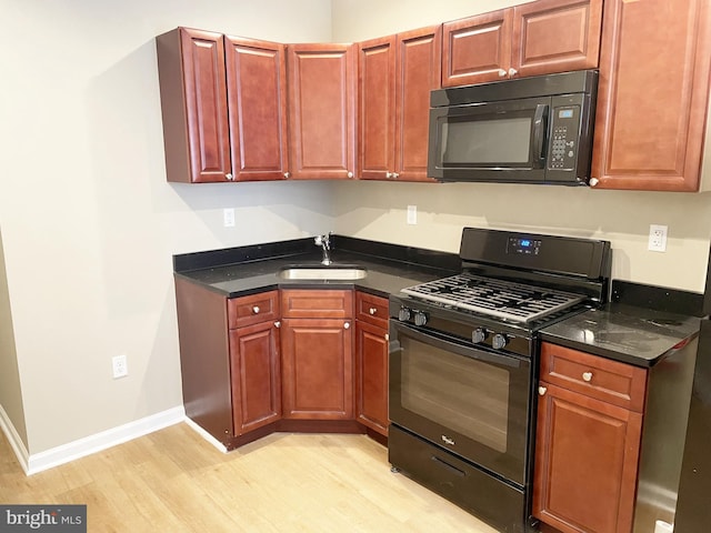 978 N 45th St, Philadelphia, PA 19104 - kitchen featuring black appliances, a sink, light wood-style floors, and baseboards